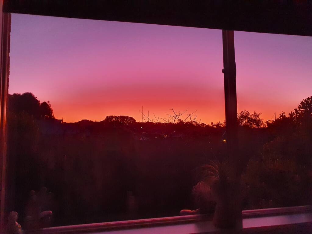 Red and pink sky, image taken through a window