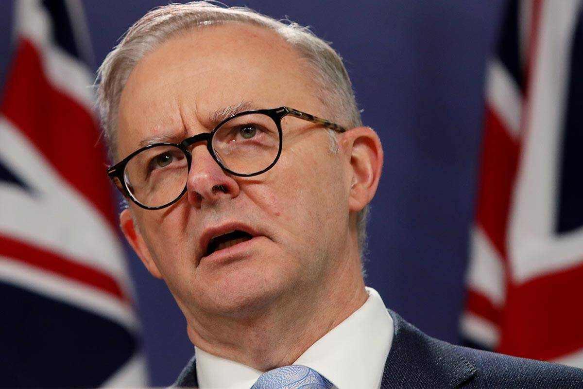 Anthony Albanese standing in front of an Australian flag